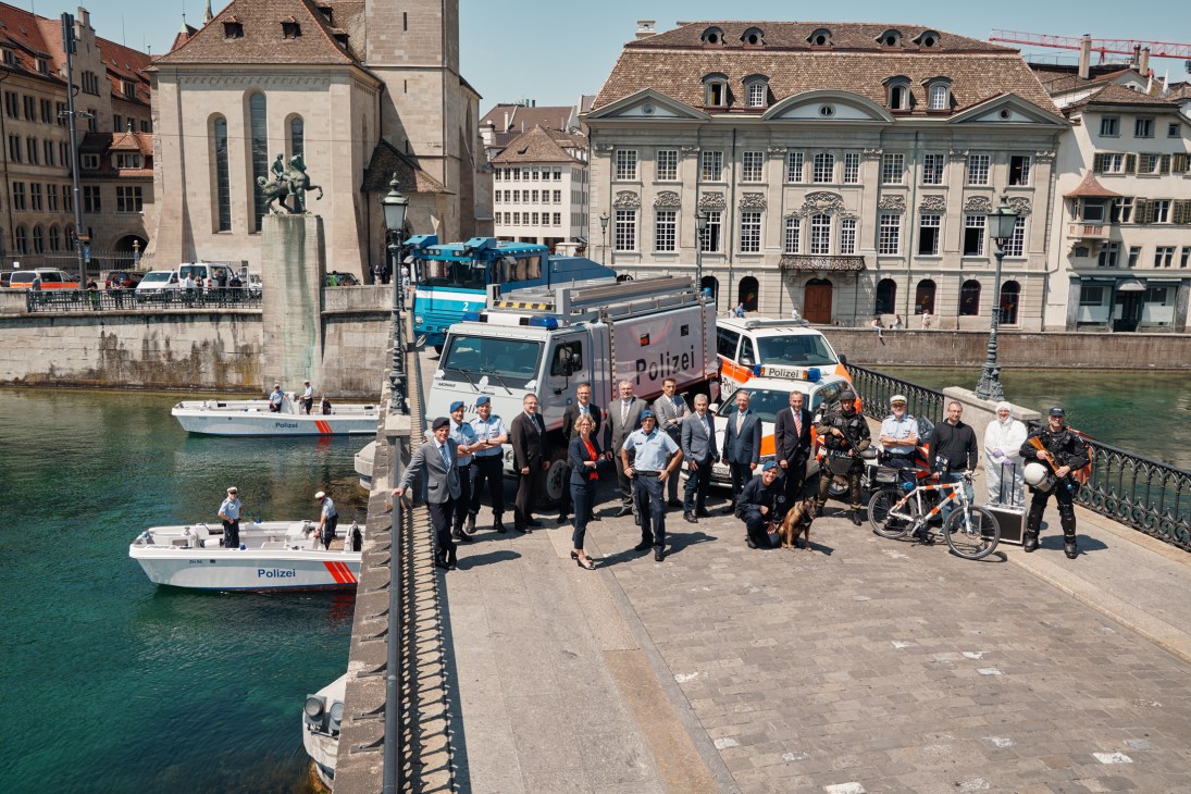 Zürich police chief Daniel Blumer and leadership team posed with emergency vehicles and equipment by the river.
