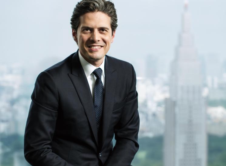 Hervé Mazella, general manager of Park Hyatt Tokyo, smiling in a dark suit against a cityscape backdrop.
