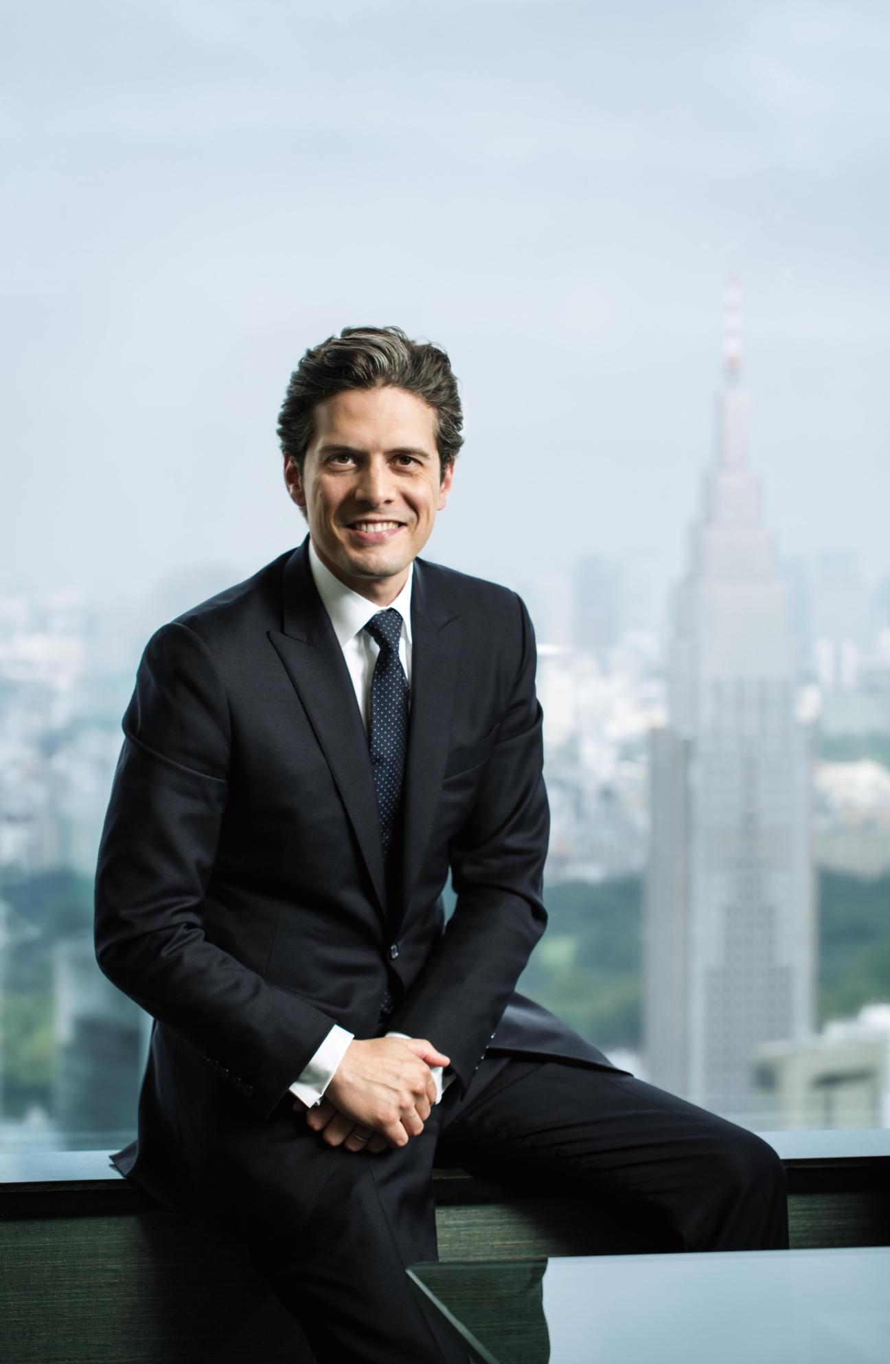 Hervé Mazella, general manager of Park Hyatt Tokyo, smiling in a dark suit against a cityscape backdrop.