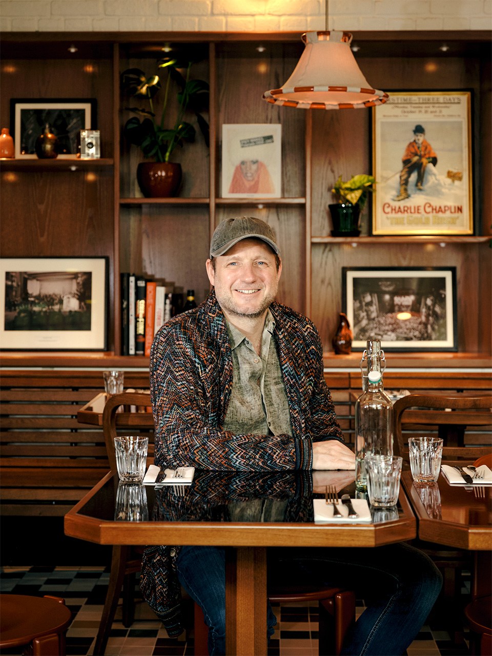 Olly Bengough, a man in dark clothing, standing in a modern cafe space with warm lighting