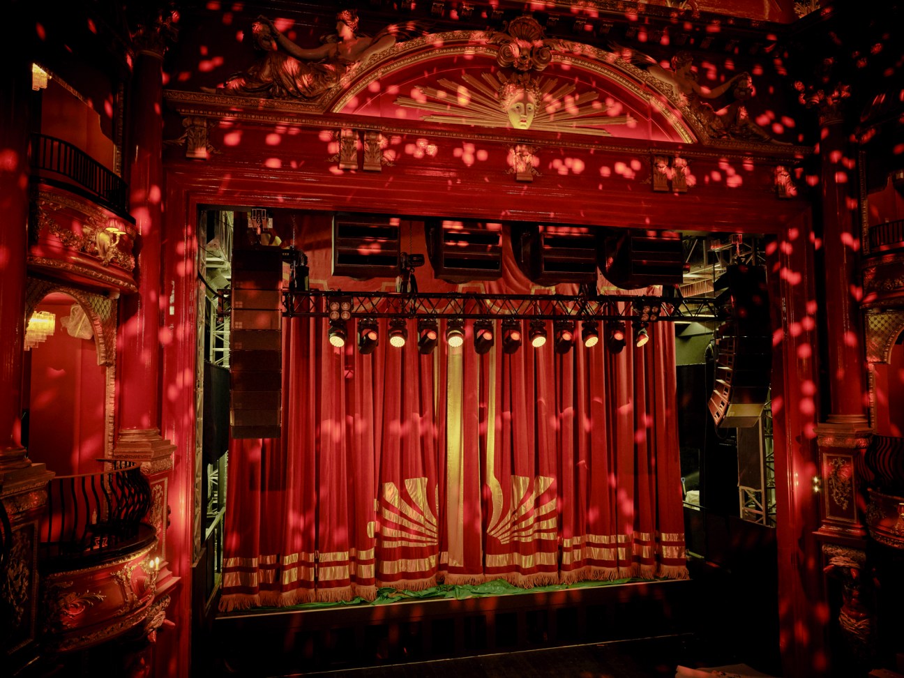 Historic theatre interior with ornate Victorian architecture, red seating, and restored period details