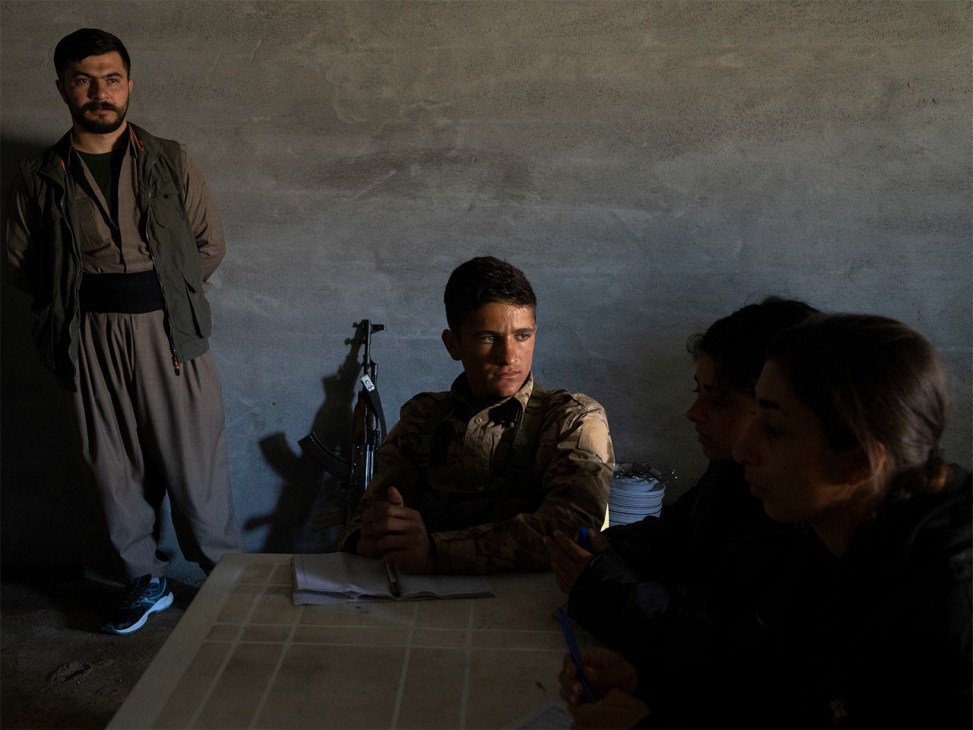 Students in a classroom taking notes while listening to a political lecture