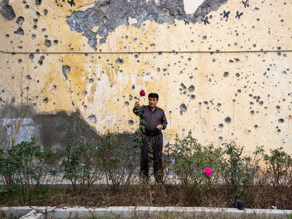 Exterior view of the Democratic Party of Iranian Kurdistan (KDPI) base building with a single rose bush growing in front