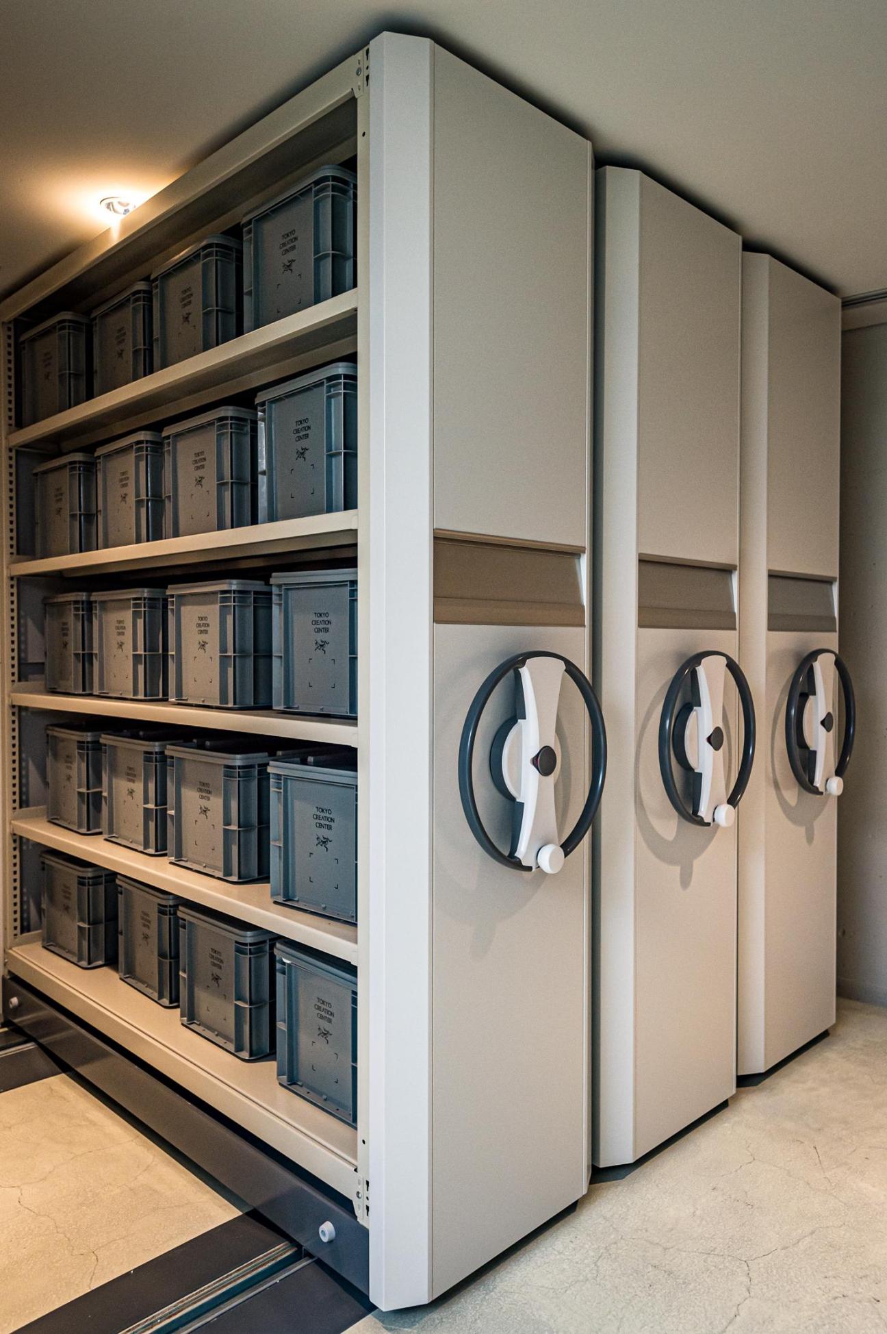 Organized shelving unit with stacked containers and three circular handles at Arc'teryx Tokyo office