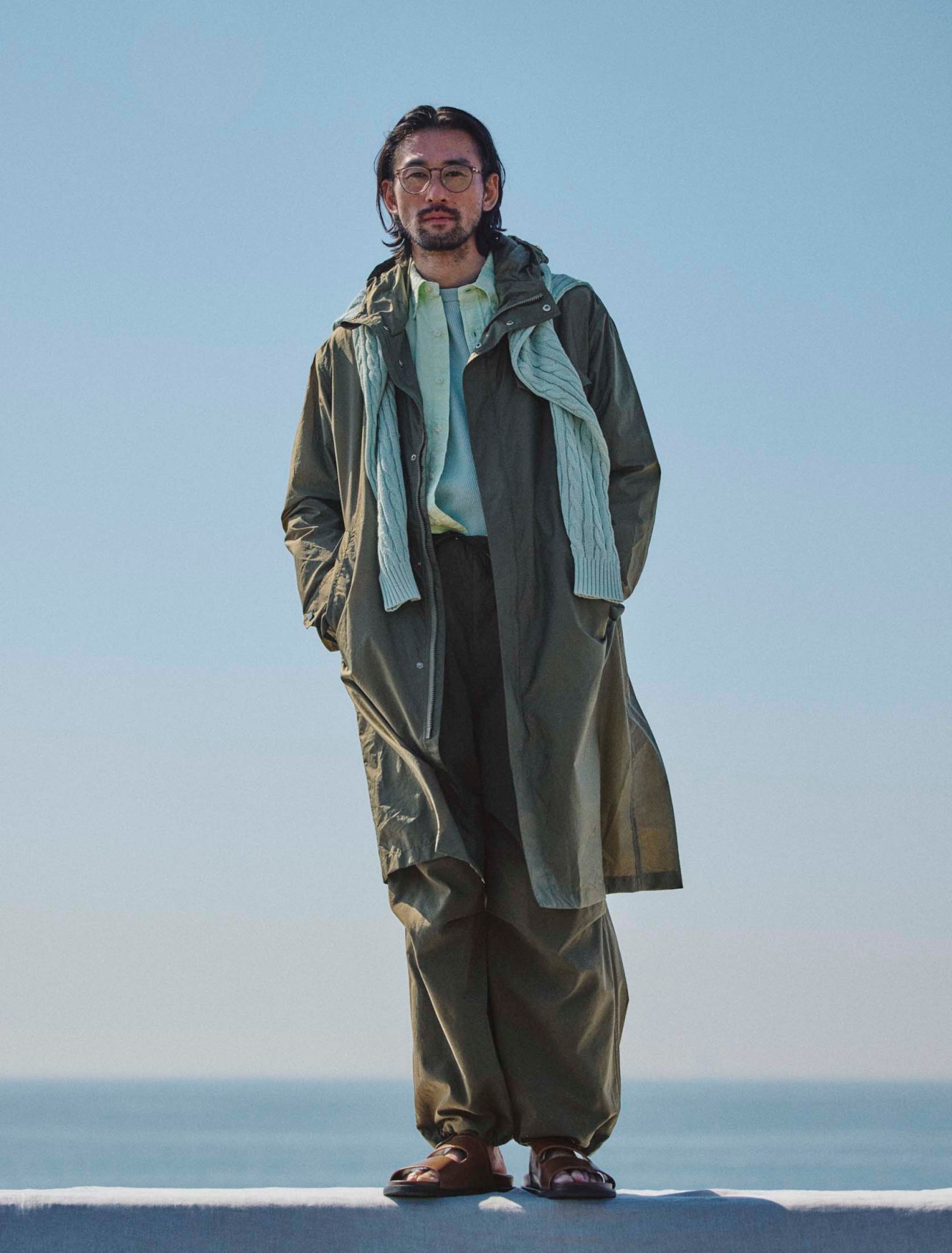 Coat by Herno, shirt by Polo Ralph Lauren, jumper by Beams Plus, thermalshirt by Polyploid, trousers by Blurhms, sandals by JM Weston, glasses by Mykita 