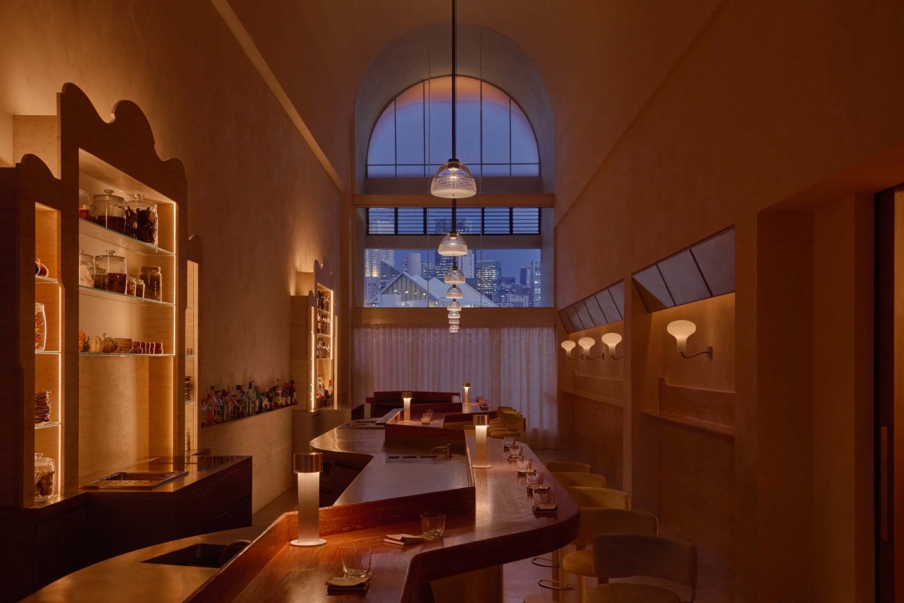 Somma Bar. An intimate space with curvilinear wood counter and dim lights 