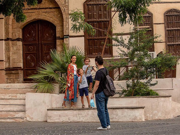 A family posing in front of a building in the old town, in Jeddah.