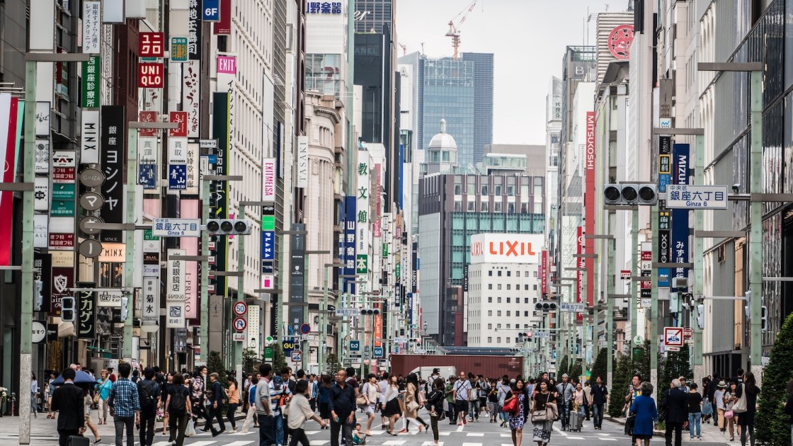 Pedestrians walking on Chuo Dori, a major street in the high-end Ginza shopping and entertainment district.