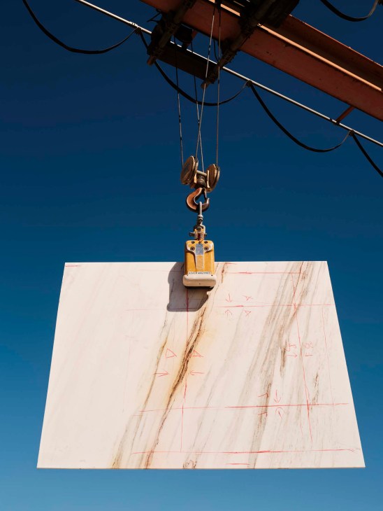 Lifting a stone slab with a crane.