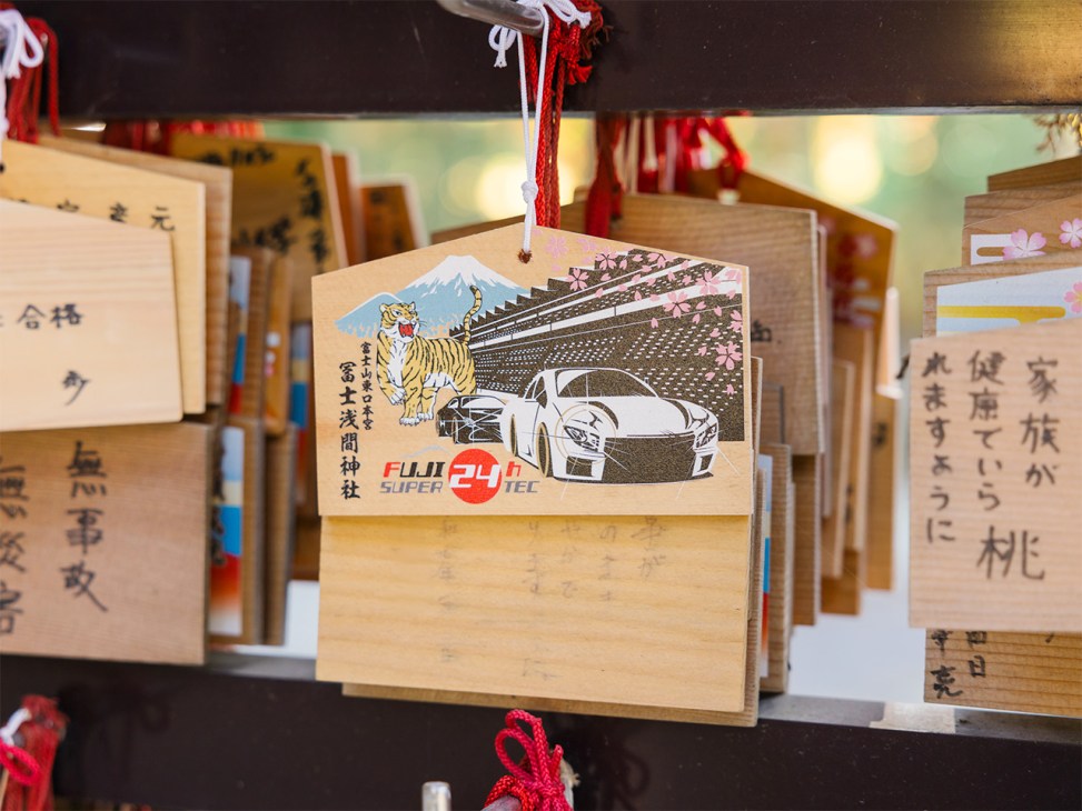 Shrine plaques featuring Fuji, flowers and the nearby racetrack