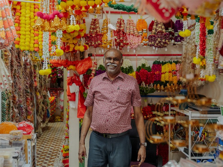 Owner of Anushia Flower Shop, R Jayaselvam, stands in front of his store