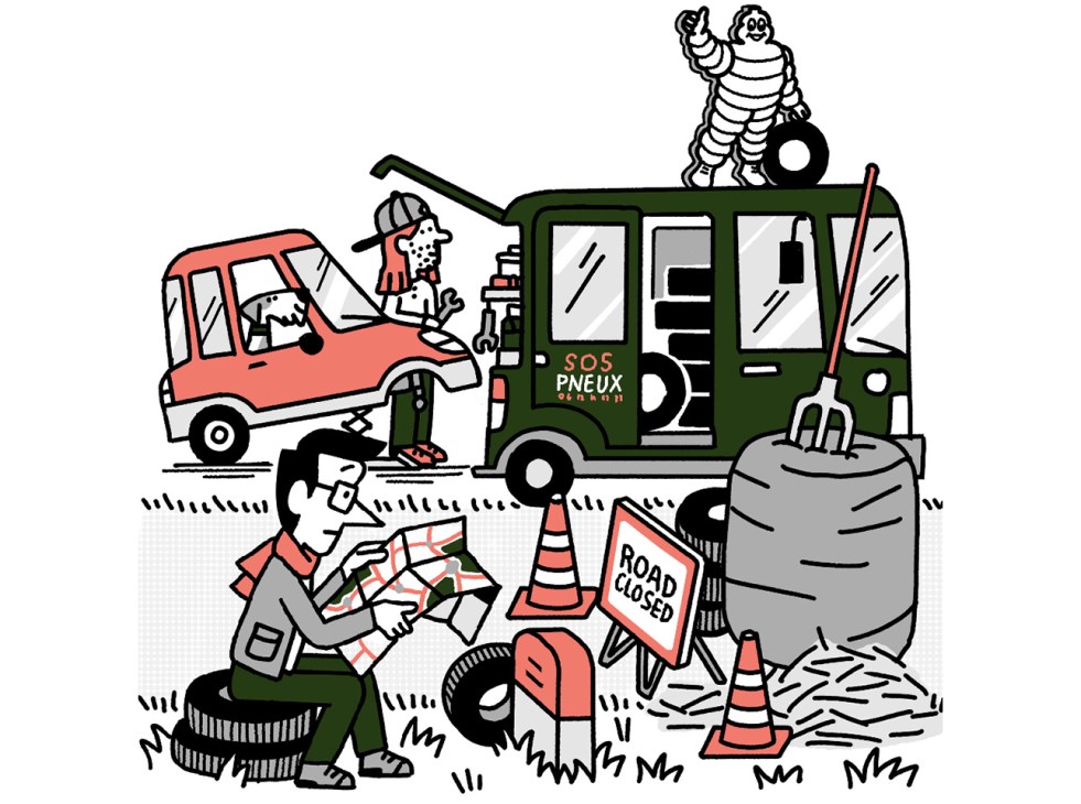 Andrew Tuck reading a map while his car gets new tyres