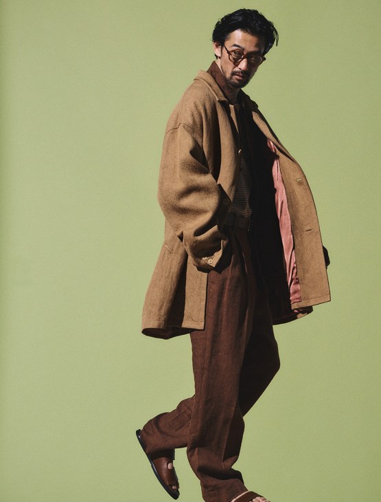 Model wearing coat by Visvim, shirt and trousers by Kaptain Sunshine, t-shirt by Circolo 1901, sandals and belt by J.M. Weston, glasses by Mykita