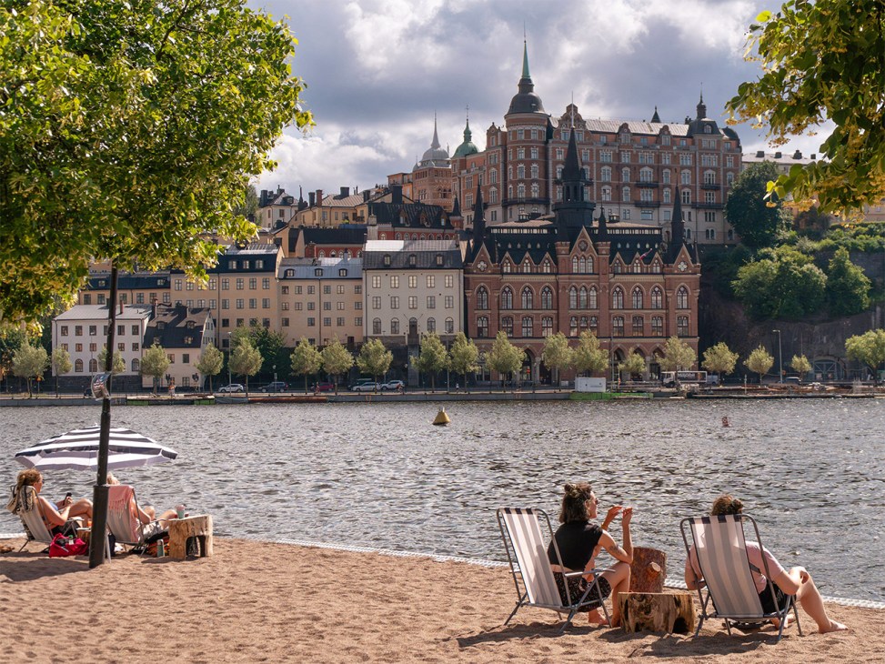 Relaxing on the island of Riddarholmen across from the historic buildings in Södermalm, Stockholm, Sweden
