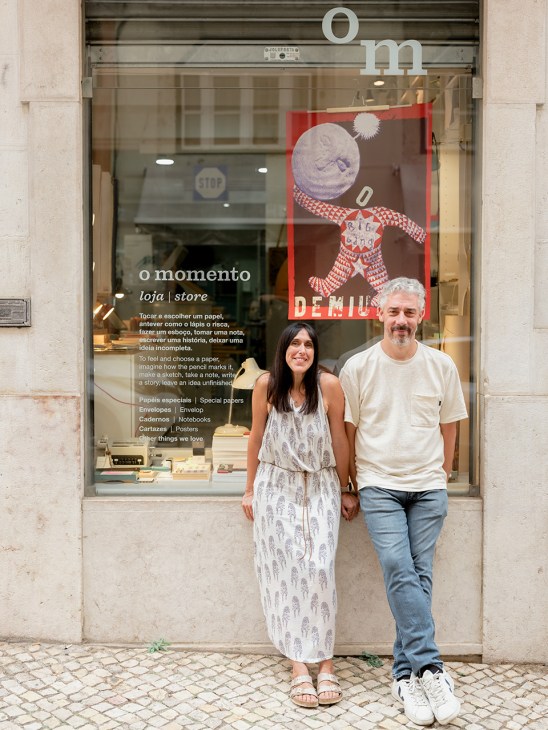 Cláudia Baeta and João Costa stand outside O Momento stationery shop in Lisbon.
