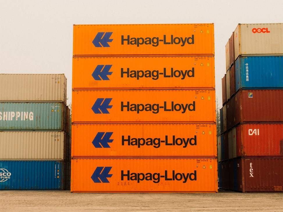 Stacked bright orange Hapag-Lloyd shipping containers ready for loading at Canxport facility in Prince Rupert.