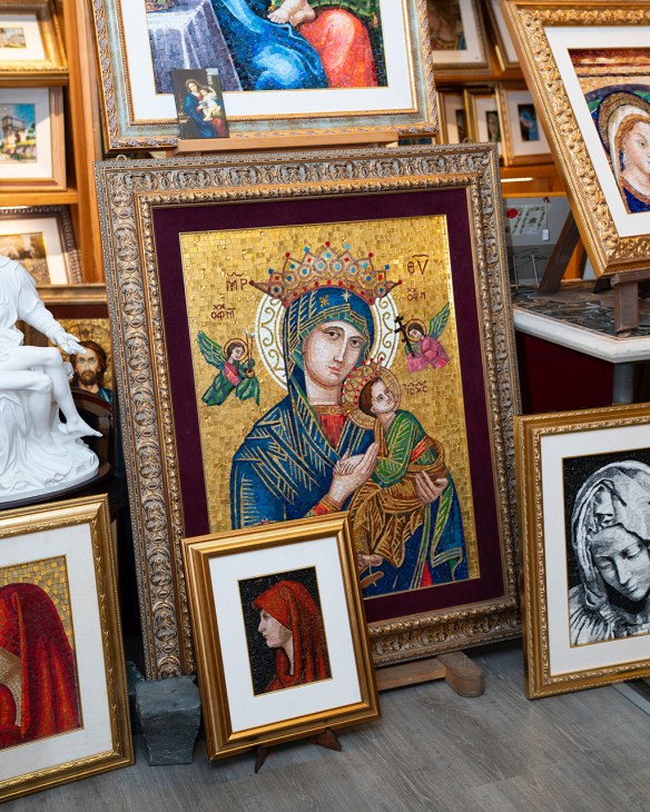 Religious icon artwork displayed in ornate gold frames at Savelli Religious shop in Rome