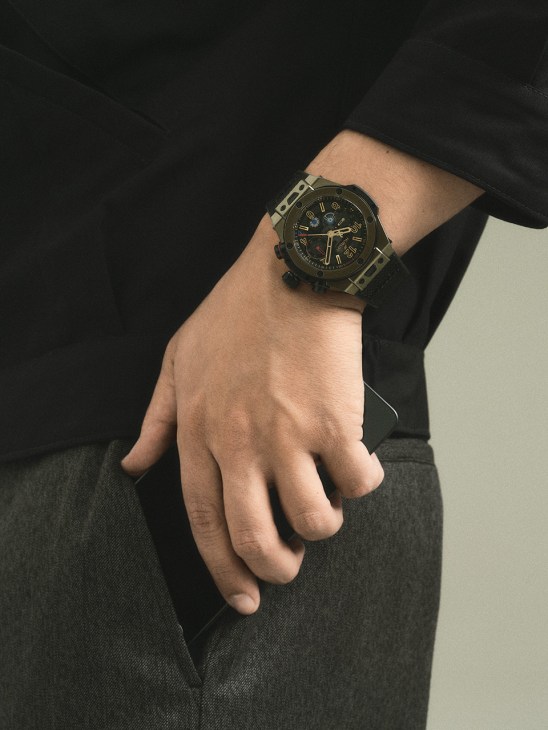 Man's wrist wearing Big Bang Reloaded Magic Gold watch by Hublot with black jacket sleeve