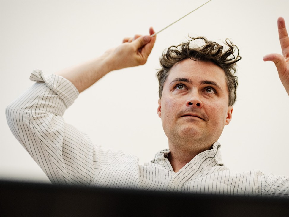 Major Emil Eliasson, musical director of the Swedish Army Band, conducting with his arm raised.