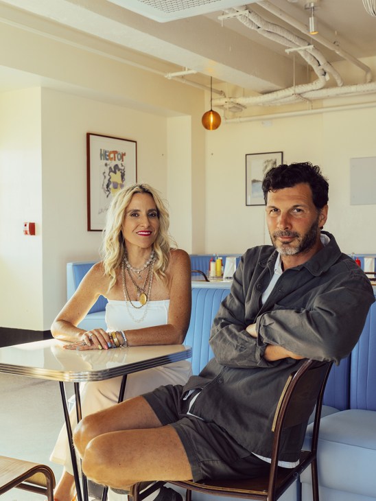 Ursula Damani and Pierre Antoine Dourneau at Rockaway Ocean Club in a modern office interior with blue seating.