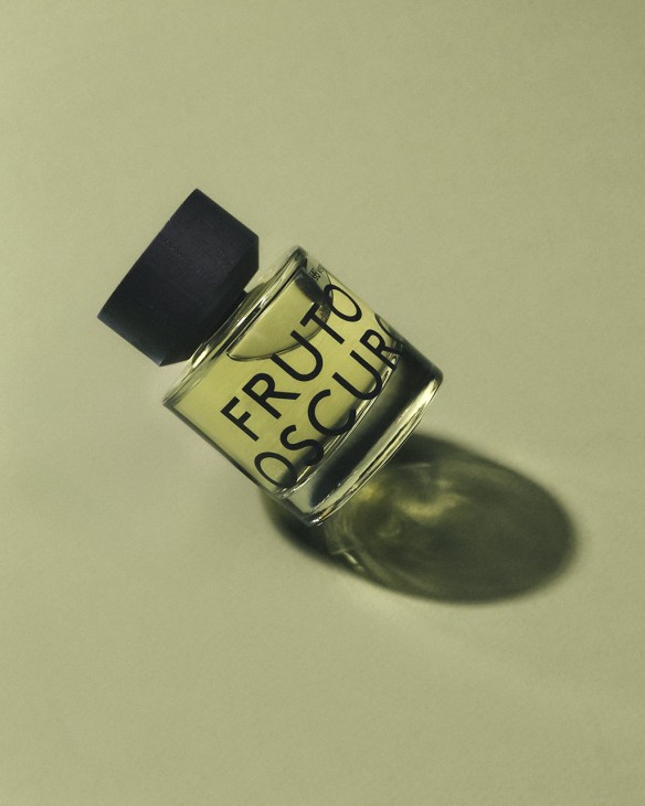Eauso Vert perfume bottle with pale yellow liquid and black cap casting shadow on pale background