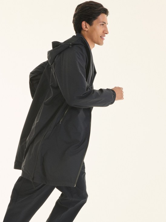 Man jogging in black hooded jacket and trousers by Ketta, a Japanese cycling brand.