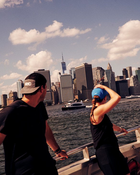 Two people on a boat viewing the Manhattan skyline across the water from Red Hook, Brooklyn.