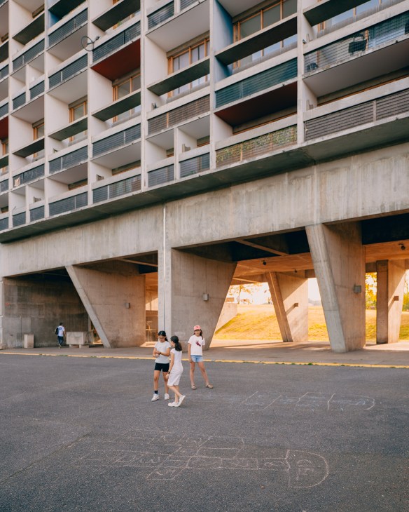Children playing under the concrete pillars of Le Corbusier's Unité d'Habitation in Firminy