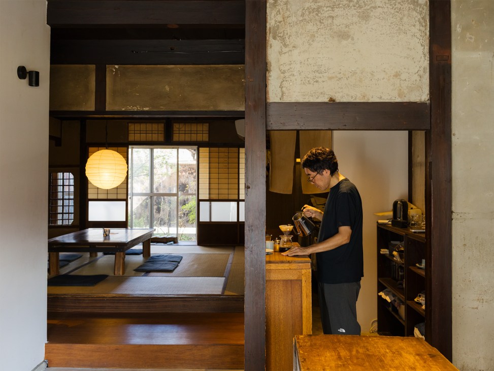 Barista Hiroya Mashimo preparing coffee at Iwashi Coffee in a traditional Japanese wooden interior space.