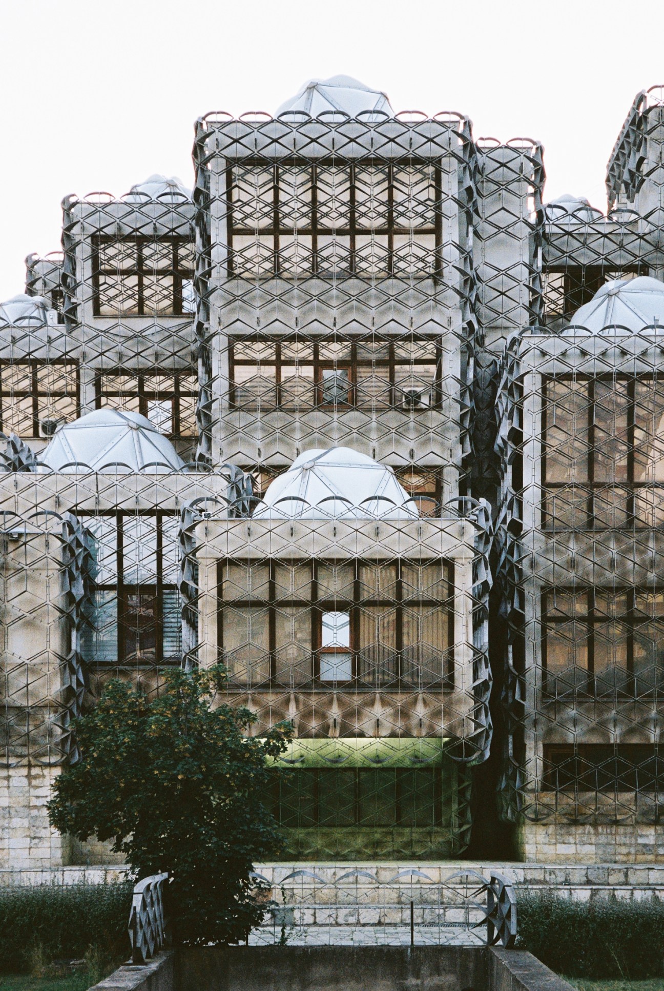 Distinctive brutalist architecture of Kosovo National Library with geometric facade and multiple white domes