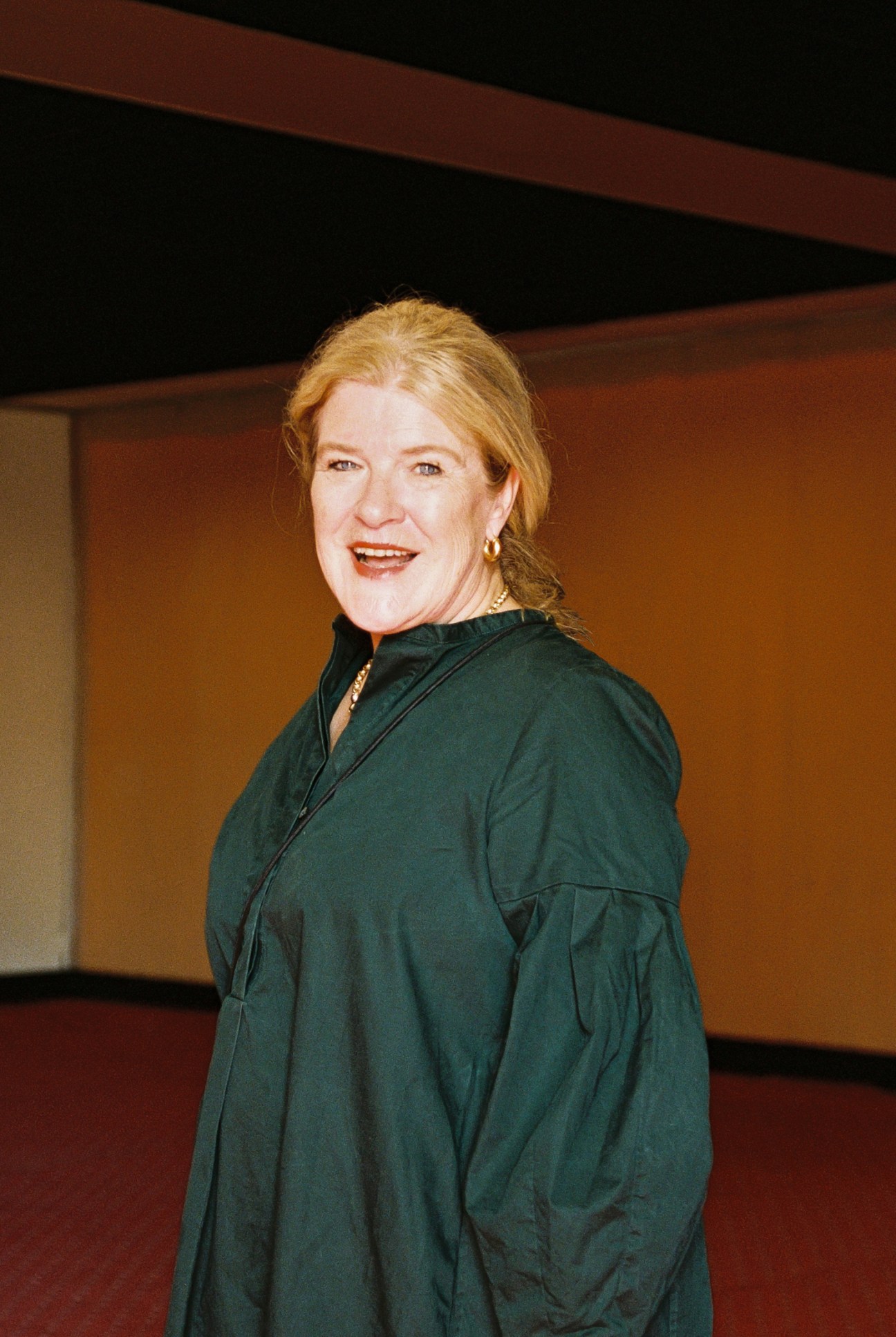 Hedwig Fijen, Manifesta director, wearing a green outfit and smiling at the camera