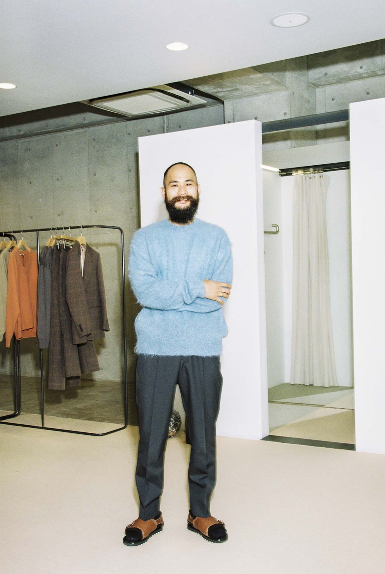 Iori Mano wearing Auralee clothing in a minimalist retail setting