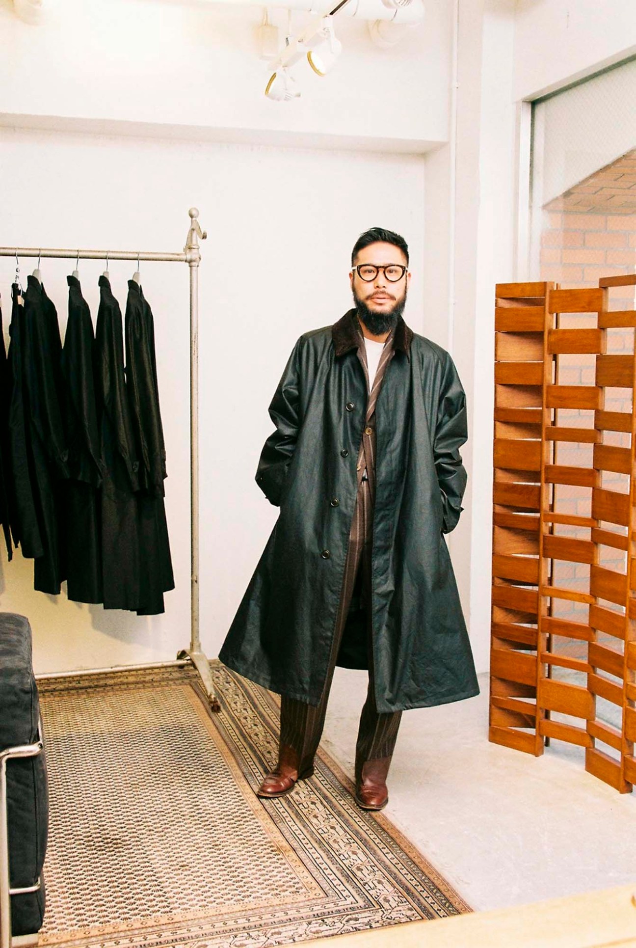 Shotaro Wada in dark oversized coat and trousers styled with vintage pieces in L'Échoppe shop