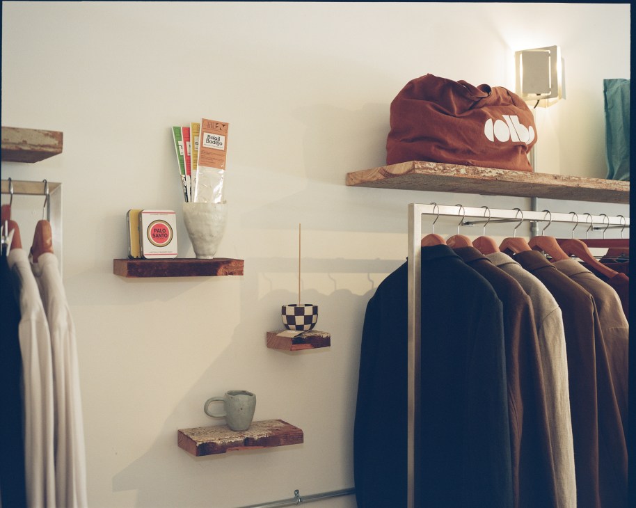 Clean merchandising display with clothing items organized on shelves and hangers in minimal retail space