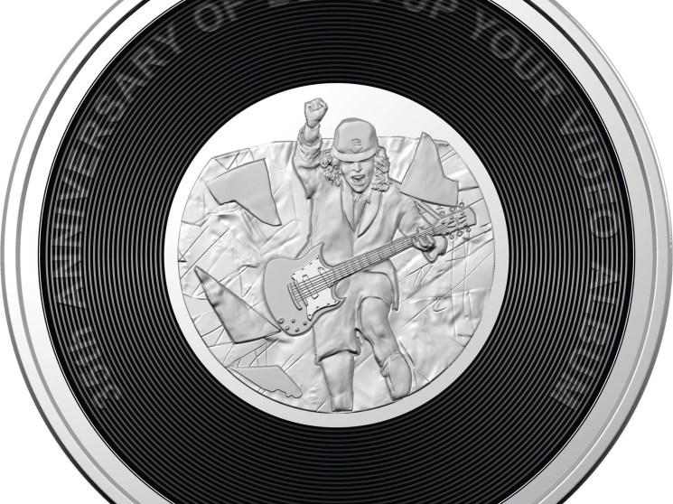 Commemorative coin featuring guitarist with AC/DC album design resembling vinyl record