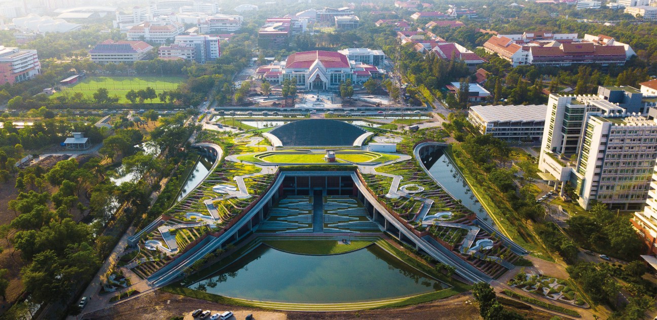 Aerial view of terraced rooftop farm with curved green planting beds integrated into building architecture