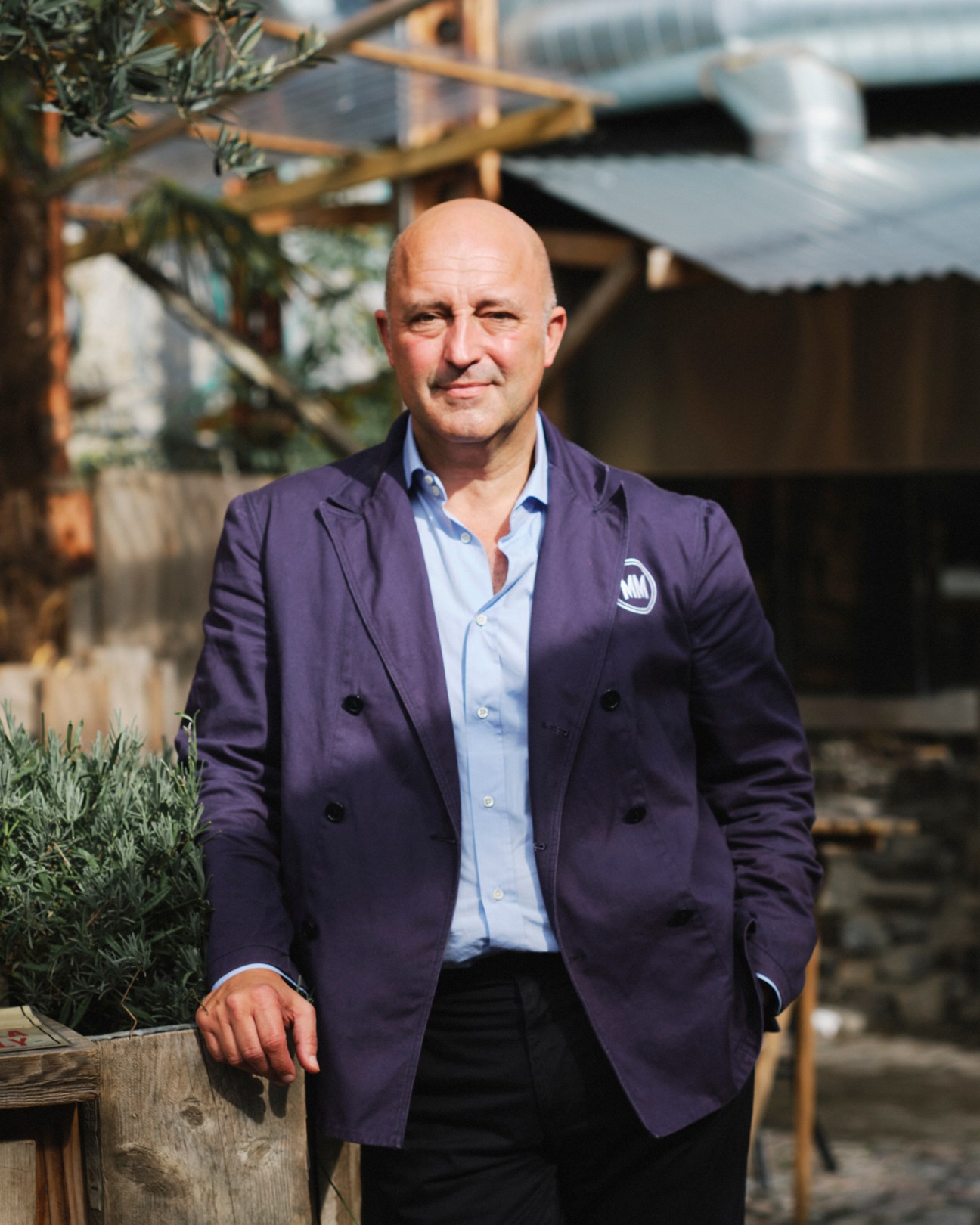 Andrea Rasca standing outdoors in a navy blazer and light blue shirt