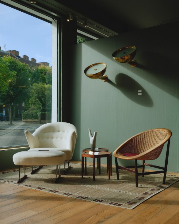 Two mid-century modern chairs in a gallery setting with natural lighting