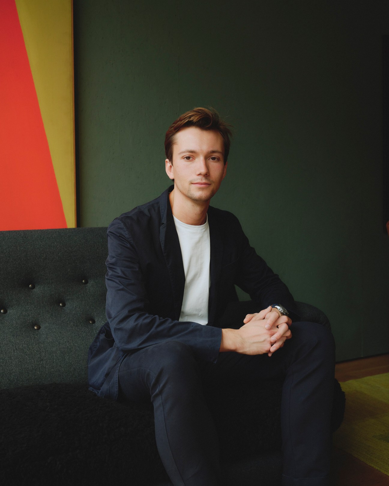 Sebastien Holt standing in a modern furniture showroom with contemporary lighting and seating