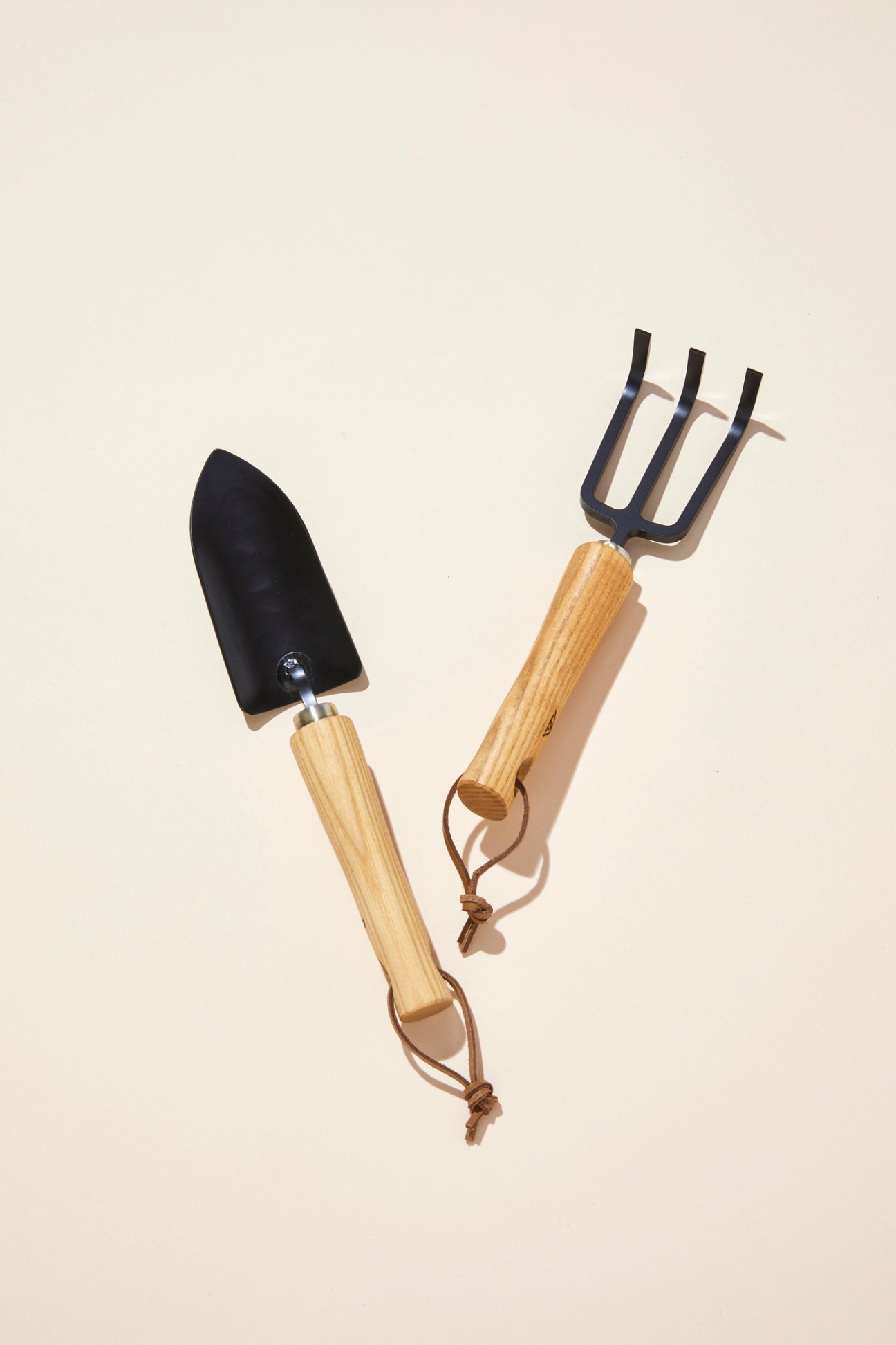 Wooden-handled hand trowel and cultivator fork from Kondo Factory with black metal heads and leather hanging straps