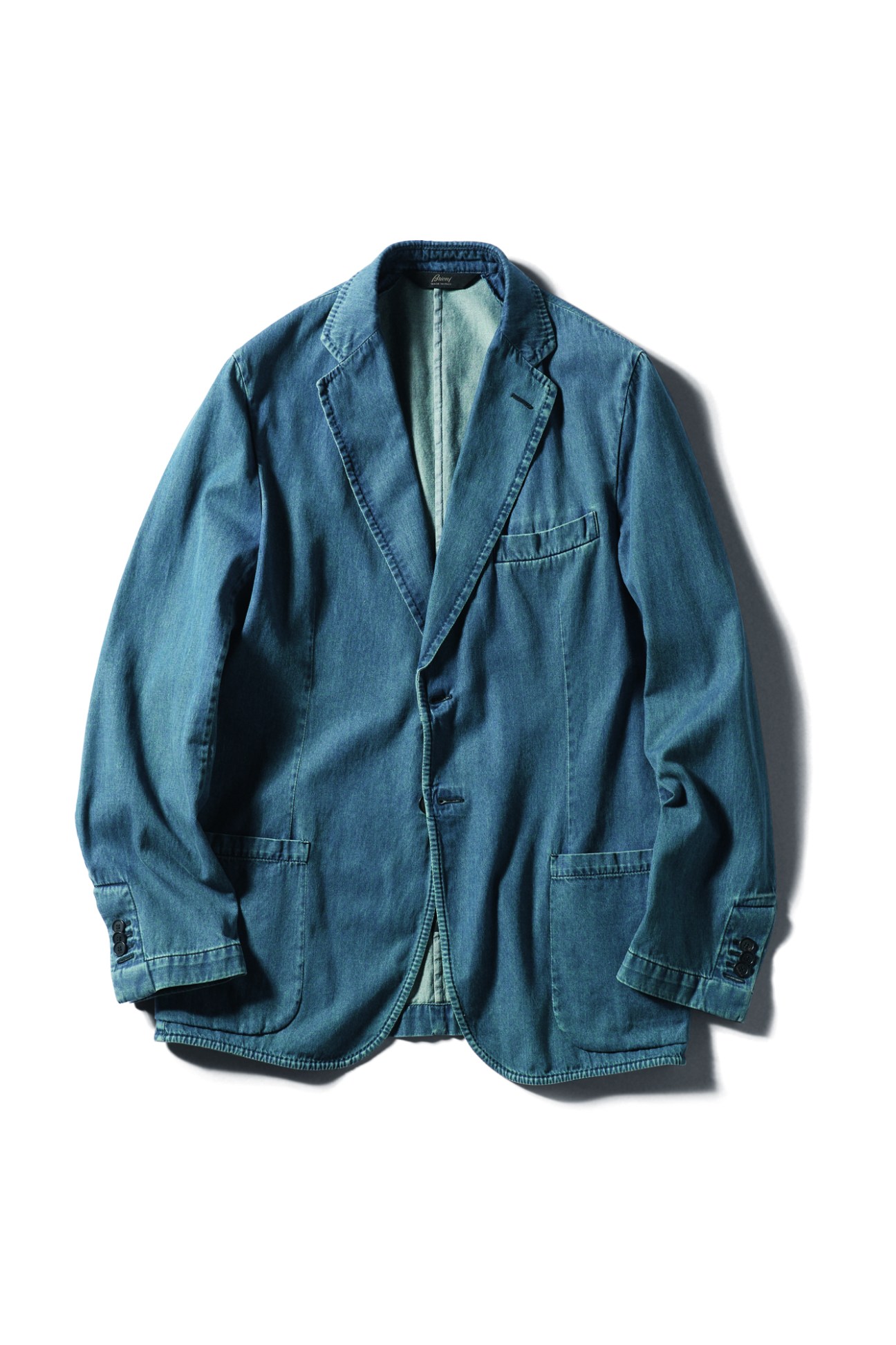 Blue denim blazer jacket by Brioni displayed against white background