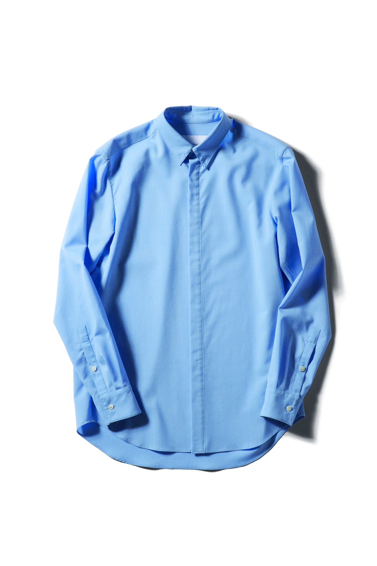 Light blue long-sleeved dress shirt by Overcoat displayed against white background
