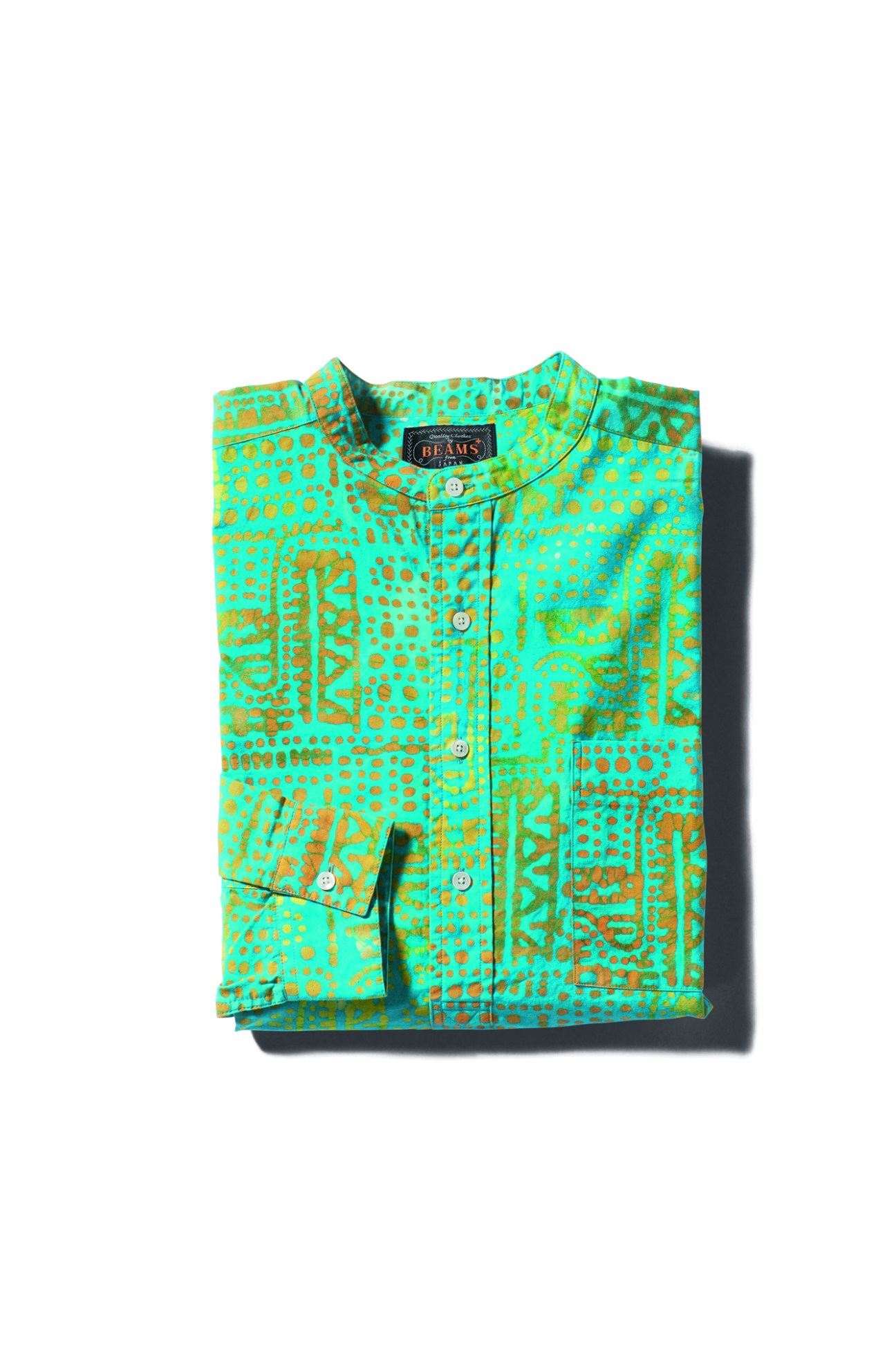 Folded green shirt with orange paisley and geometric pattern by Beams Plus