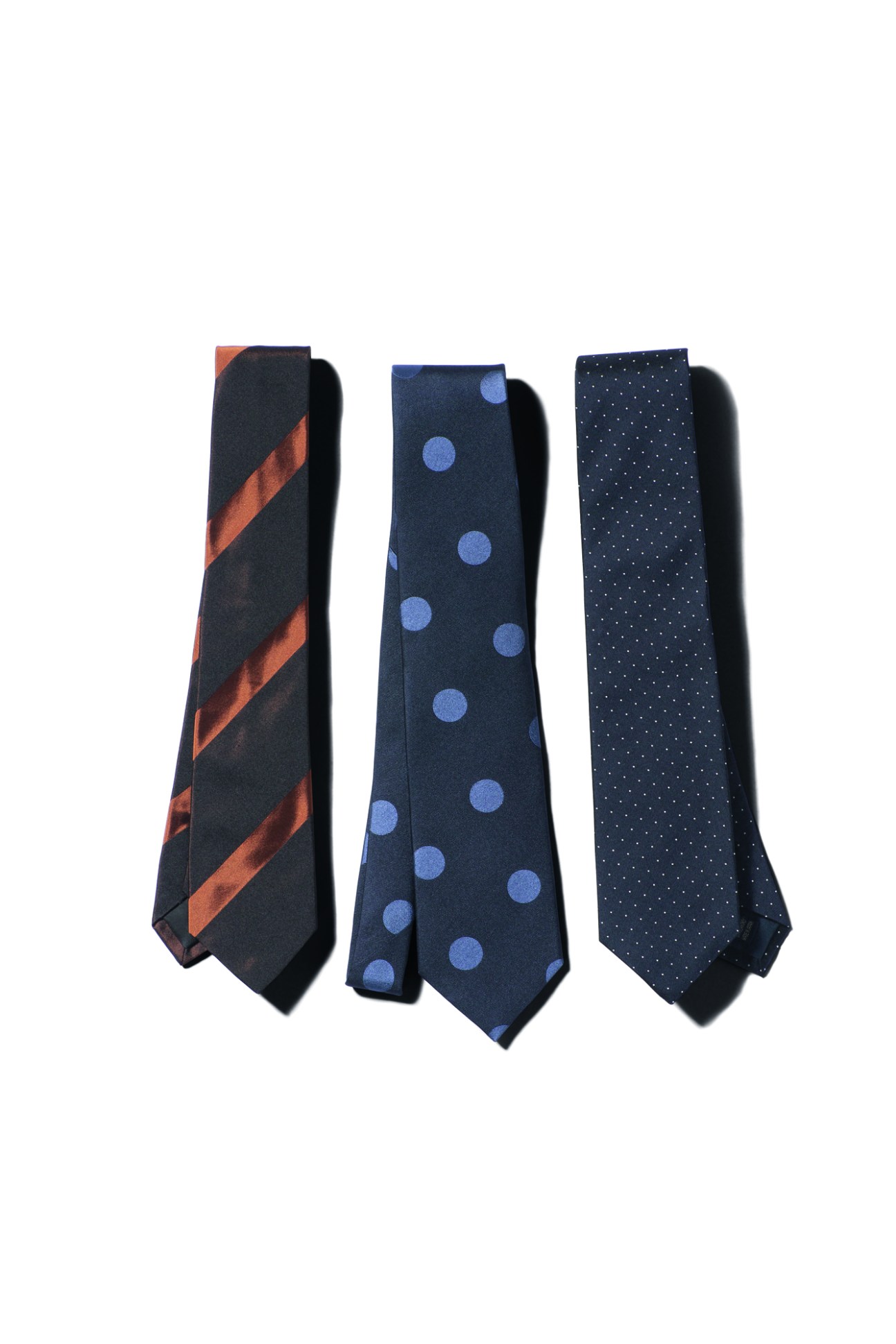 Three neckties arranged side by side showing different patterns: diagonal stripes, polka dots, and small dots