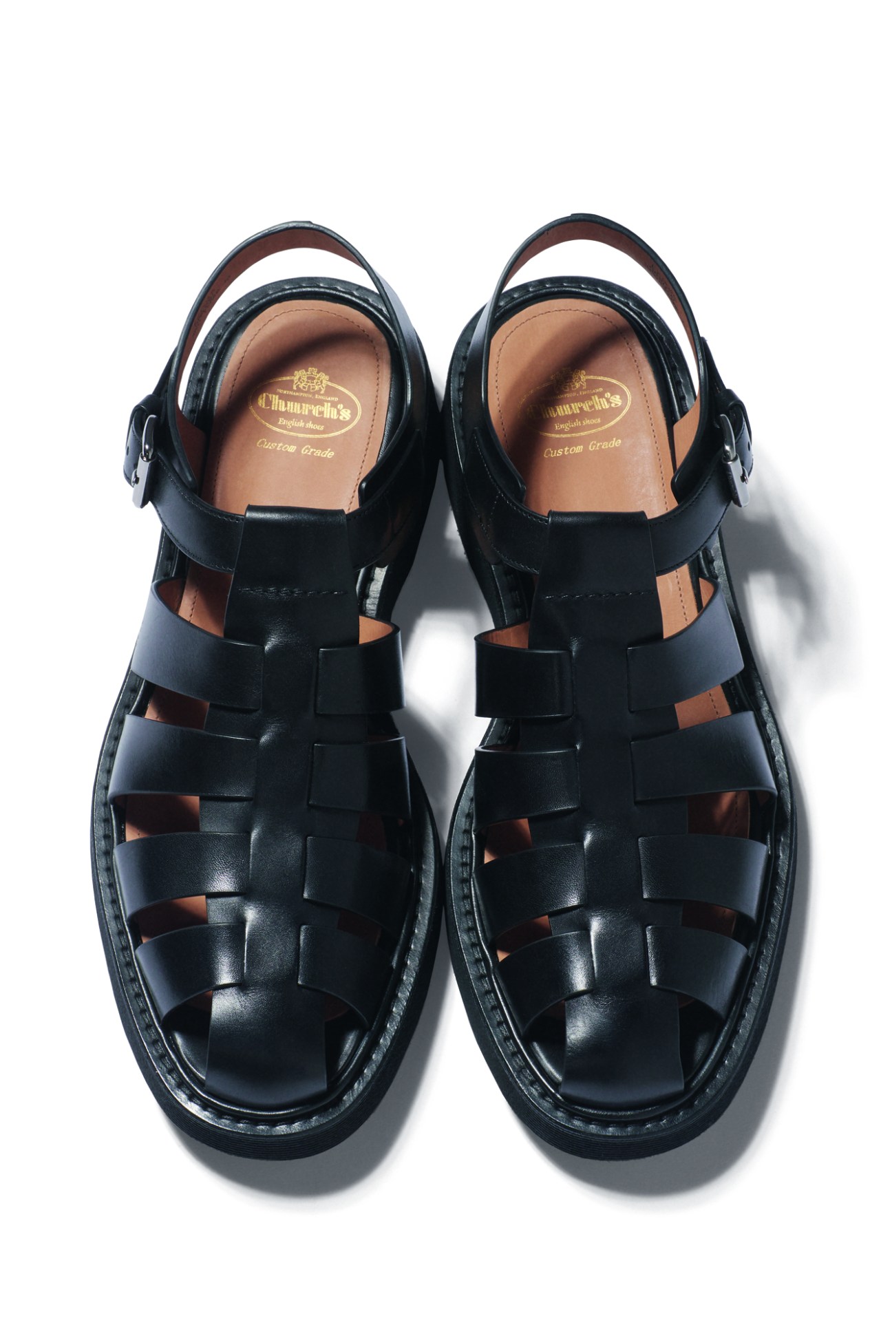Black leather sandals by Church's with woven straps and ankle buckles