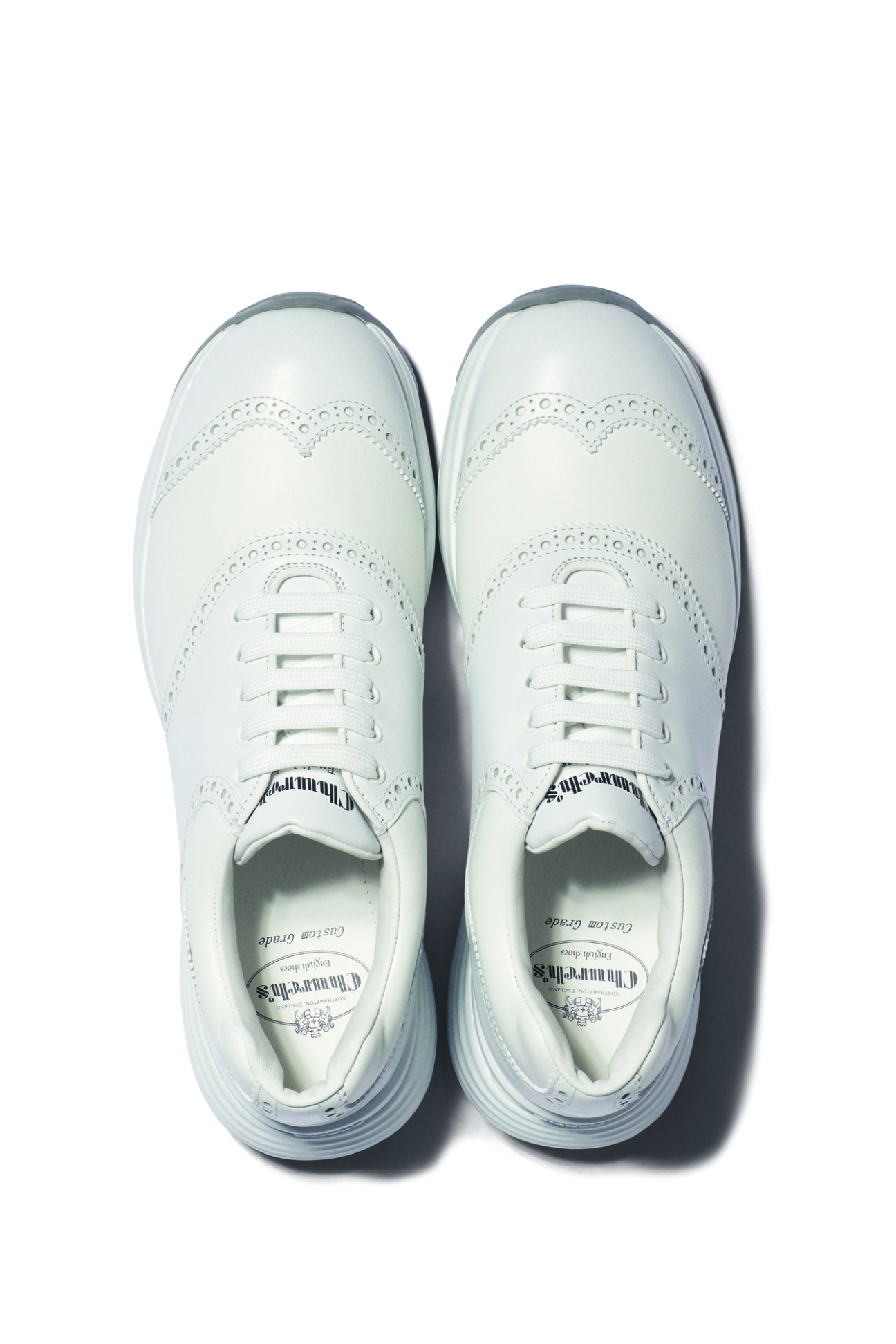 Pair of pale green trainers by Church's photographed from above against white background