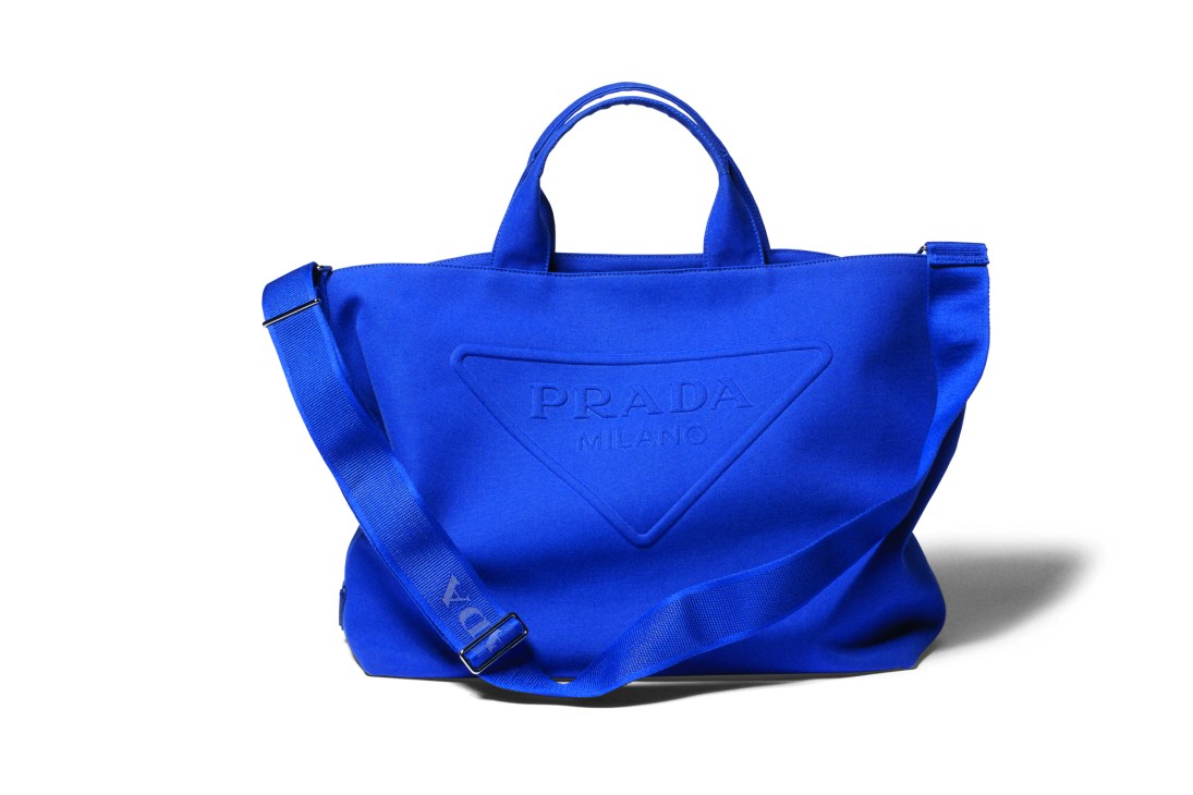 Bright blue Prada canvas tote bag with triangular logo and adjustable crossbody strap