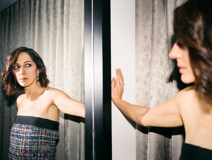 Zar Amir Ebrahimi touching a mirror with her palm in an elegant strapless dress