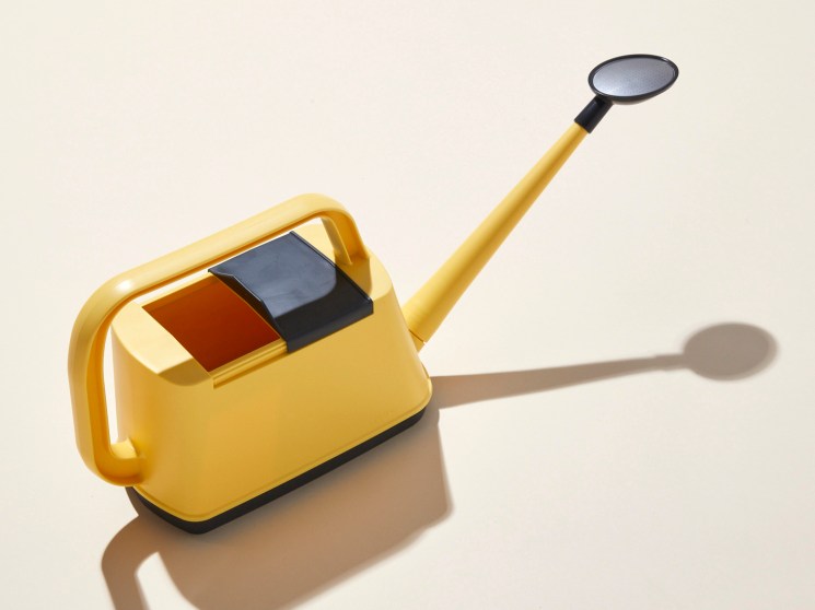 Royal Gardener's Club yellow watering can with retractable lid and long spout against beige background