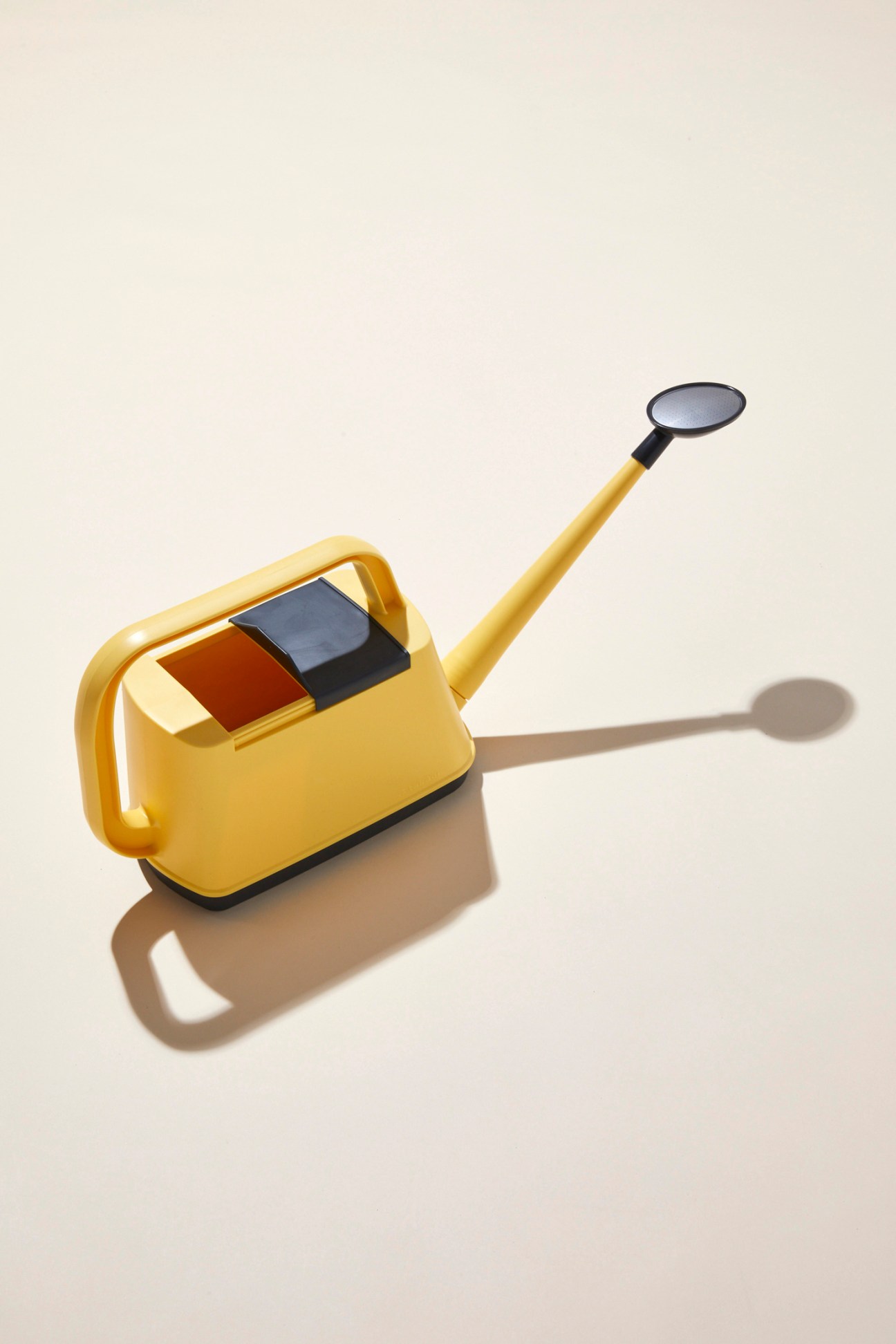 Royal Gardener's Club yellow watering can with retractable lid and long spout against beige background